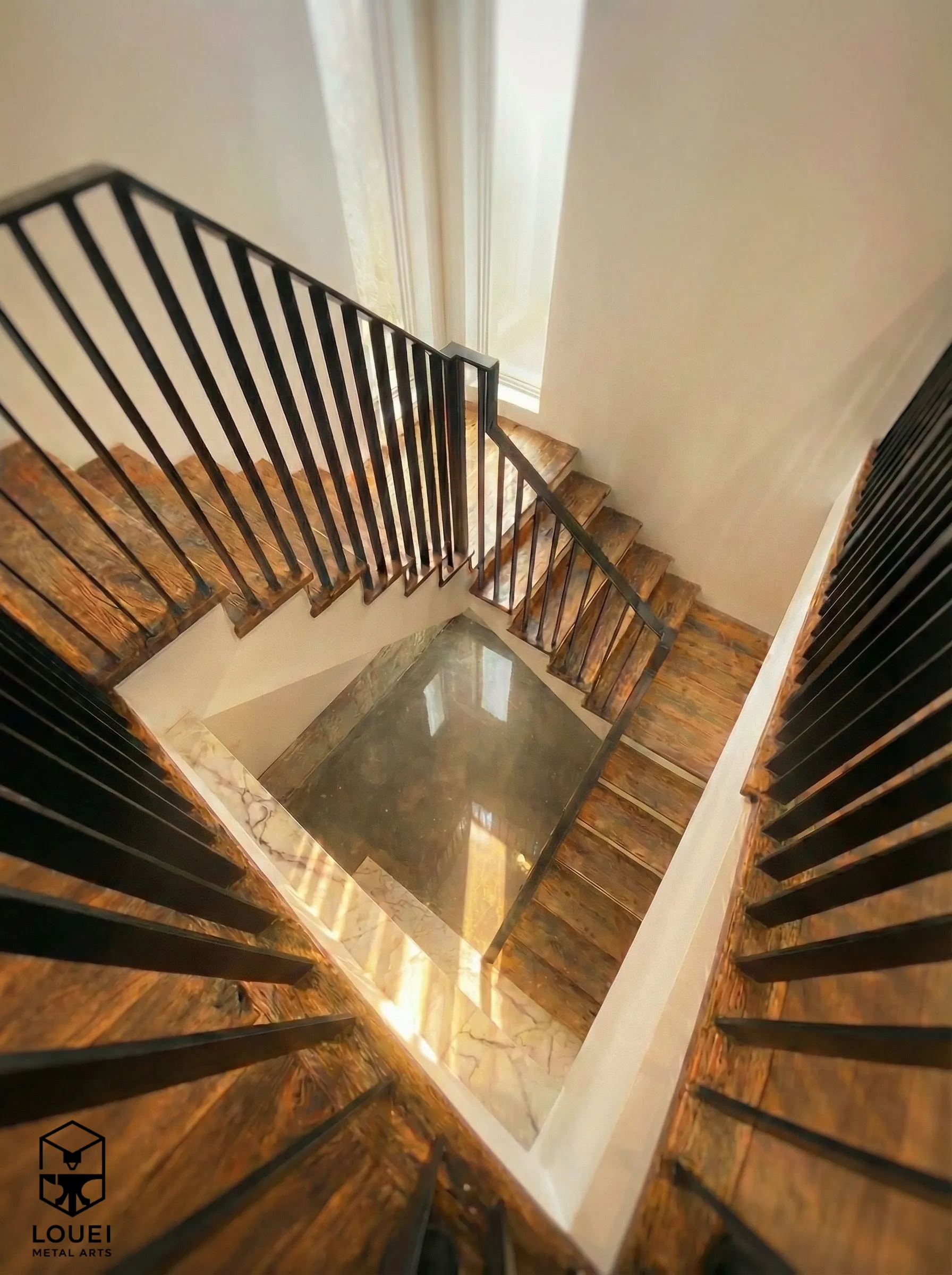 Black steel picket railings on U-shaped wood stairs in a Vancouver townhome
