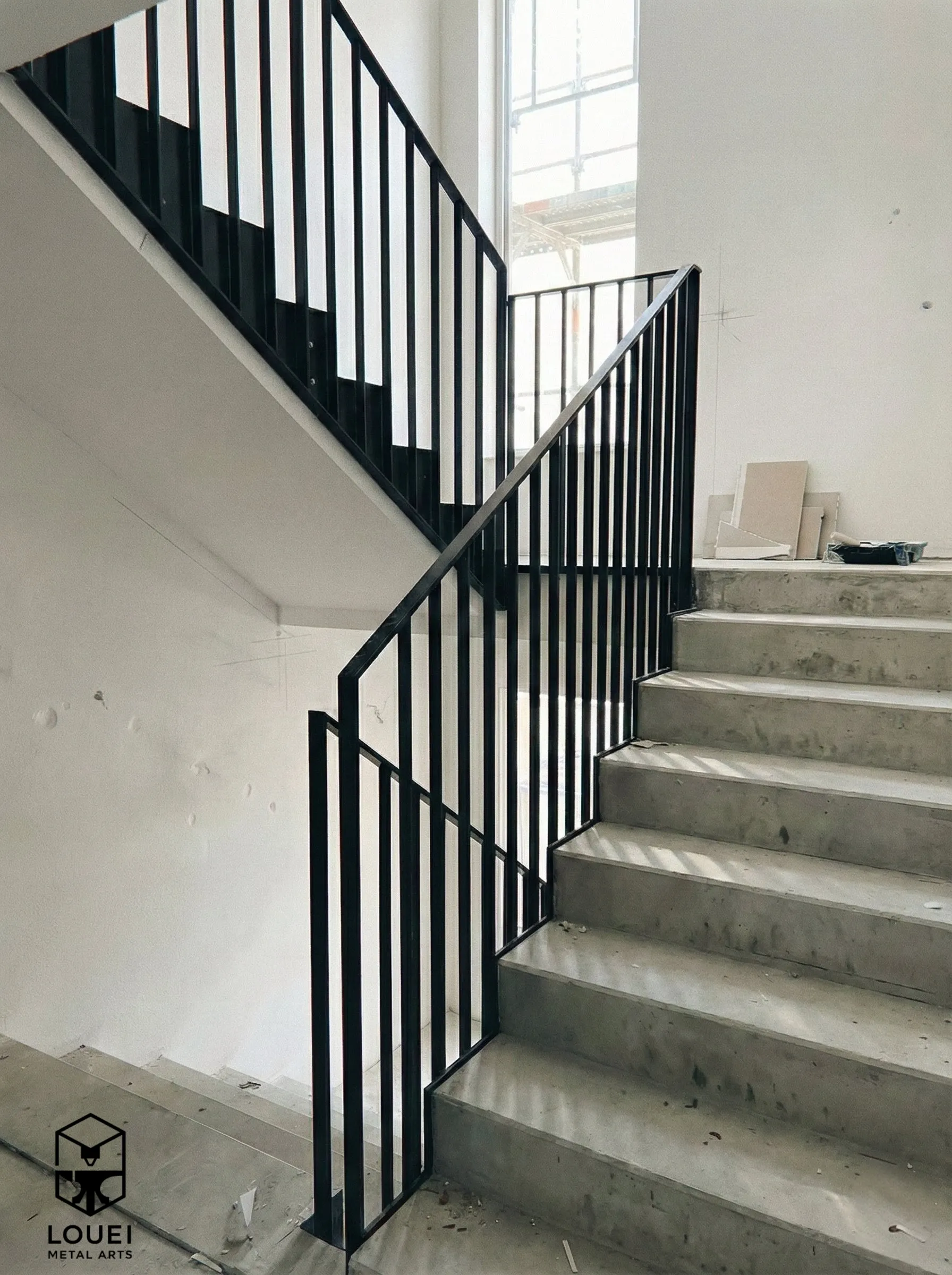 Black picket stair railing installed on concrete steps in a new construction Vancouver home
