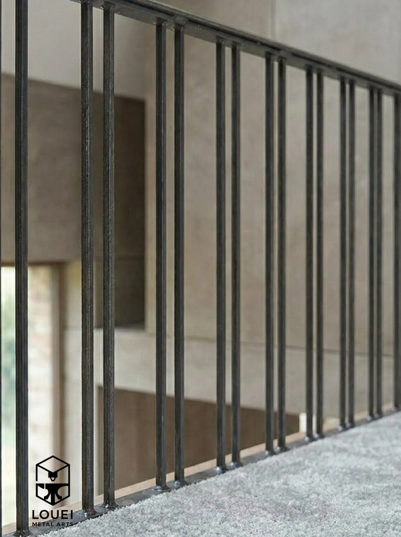 Close-up of black steel picket guardrail with carpeted floor in a Vancouver interior