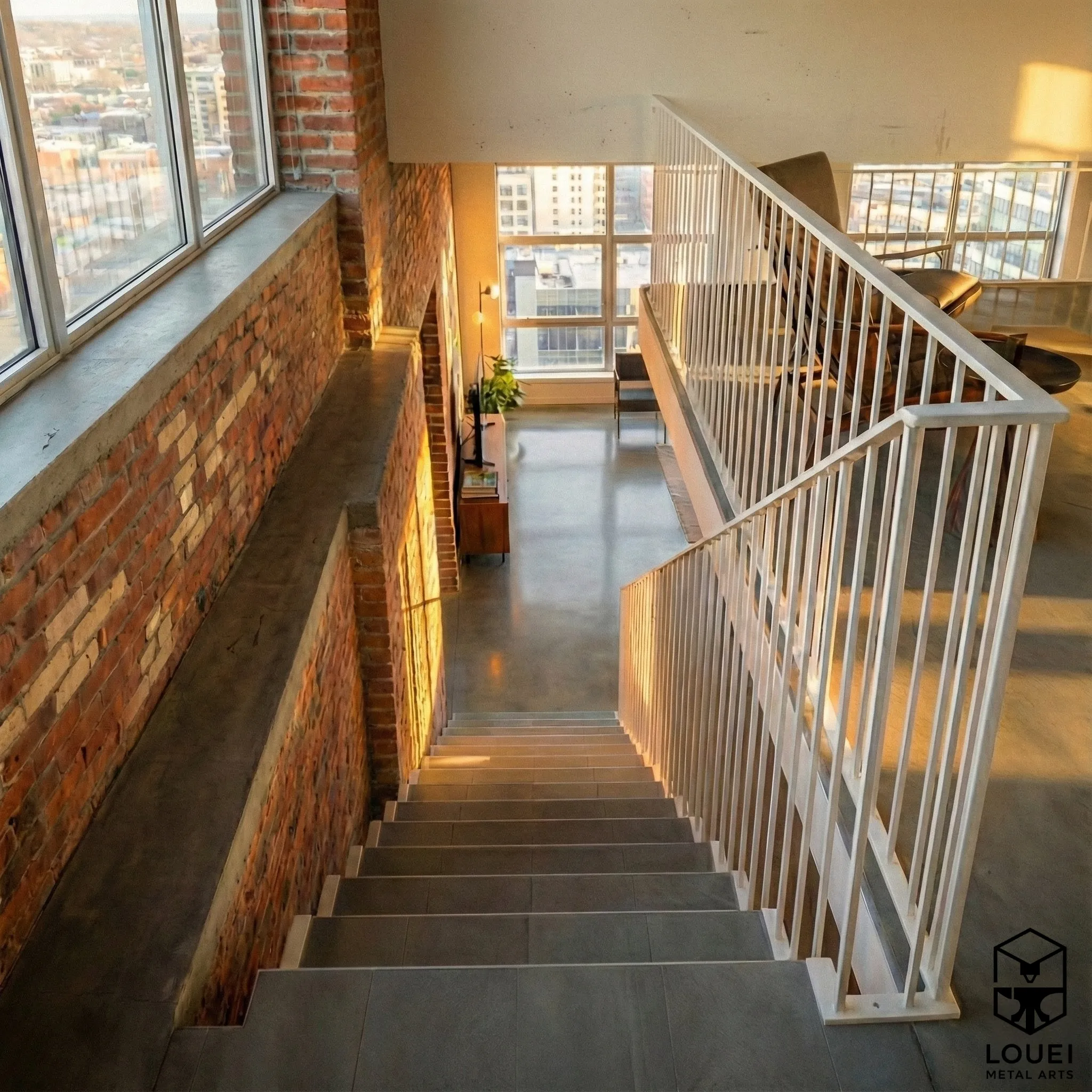 White picket stair and loft railing in an industrial Vancouver loft with brick wall
