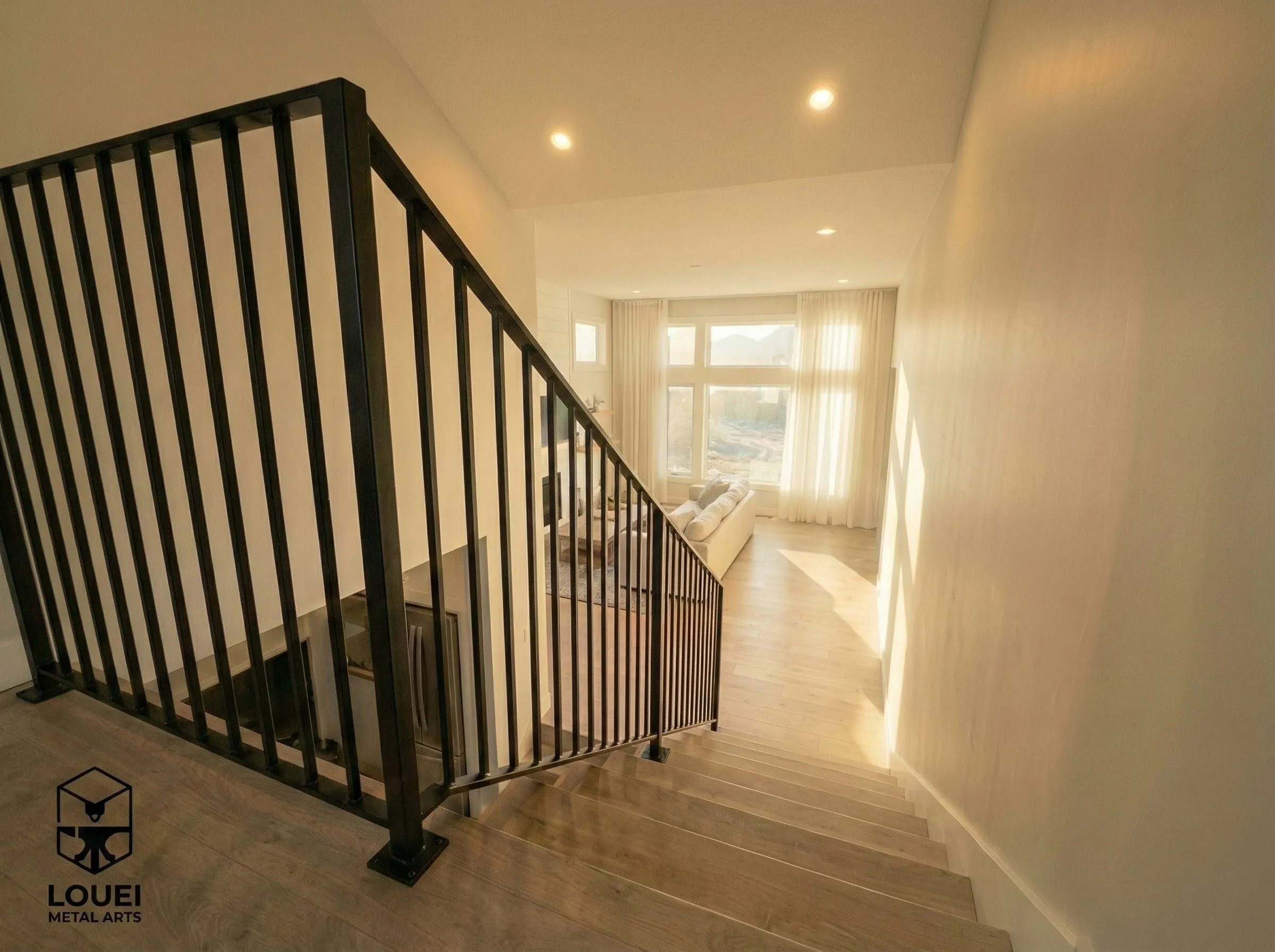 Black picket stair railing leading to bright open-concept living room in a Vancouver home