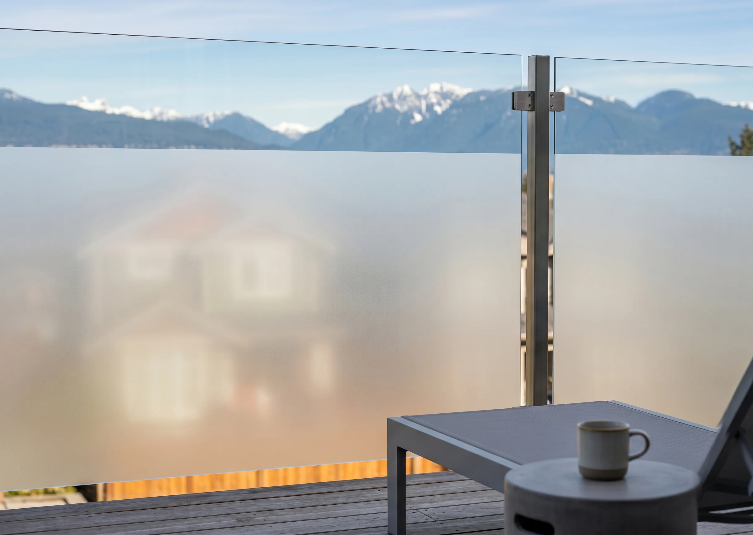Bi-level privacy glass deck railing with acid-etched frosted lower panel and clear upper panel — preserves BC ocean or mountain view while blocking neighbor sightlines
