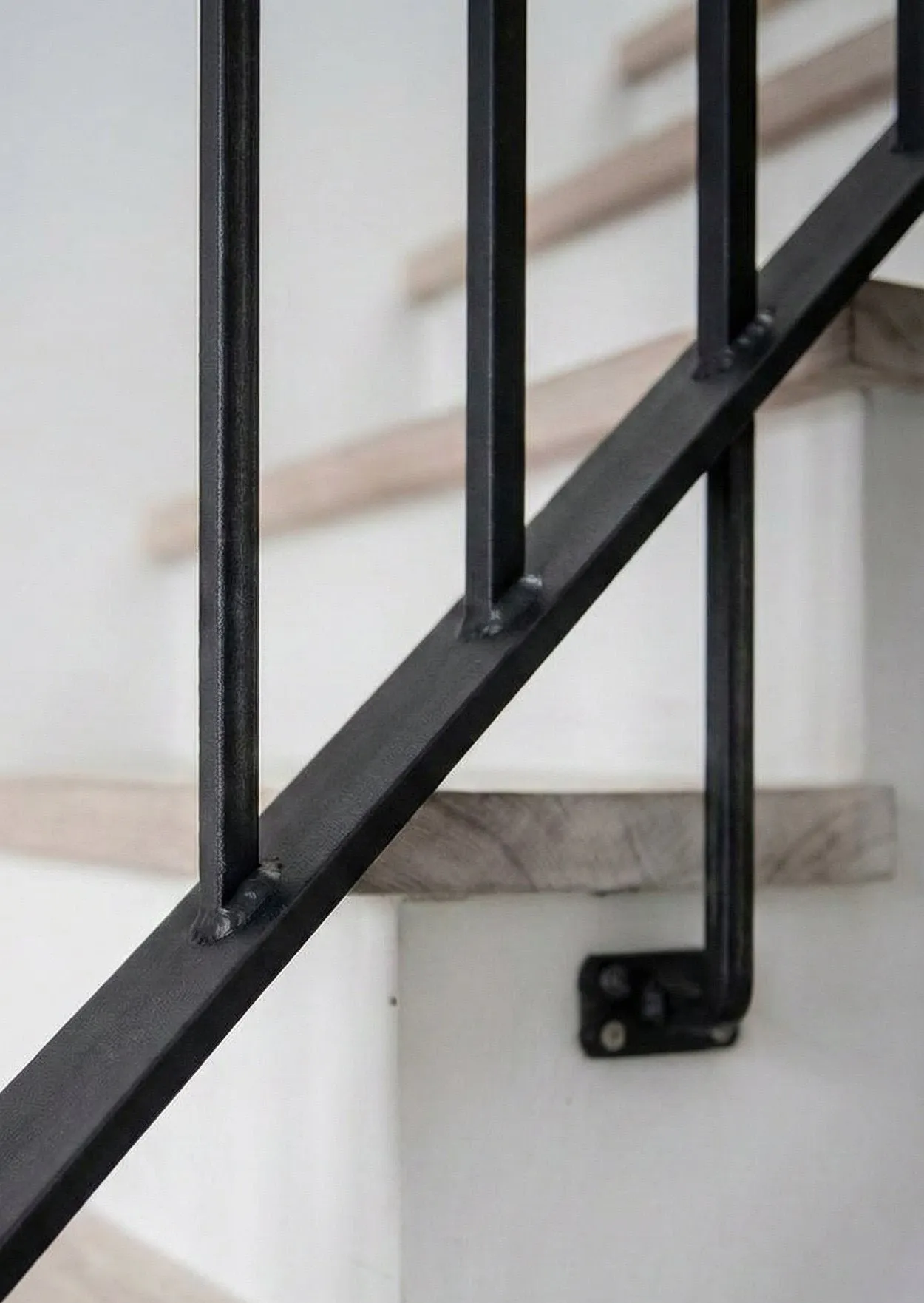 Close-up of a black powder-coated steel picket guardrail on a residential balcony.