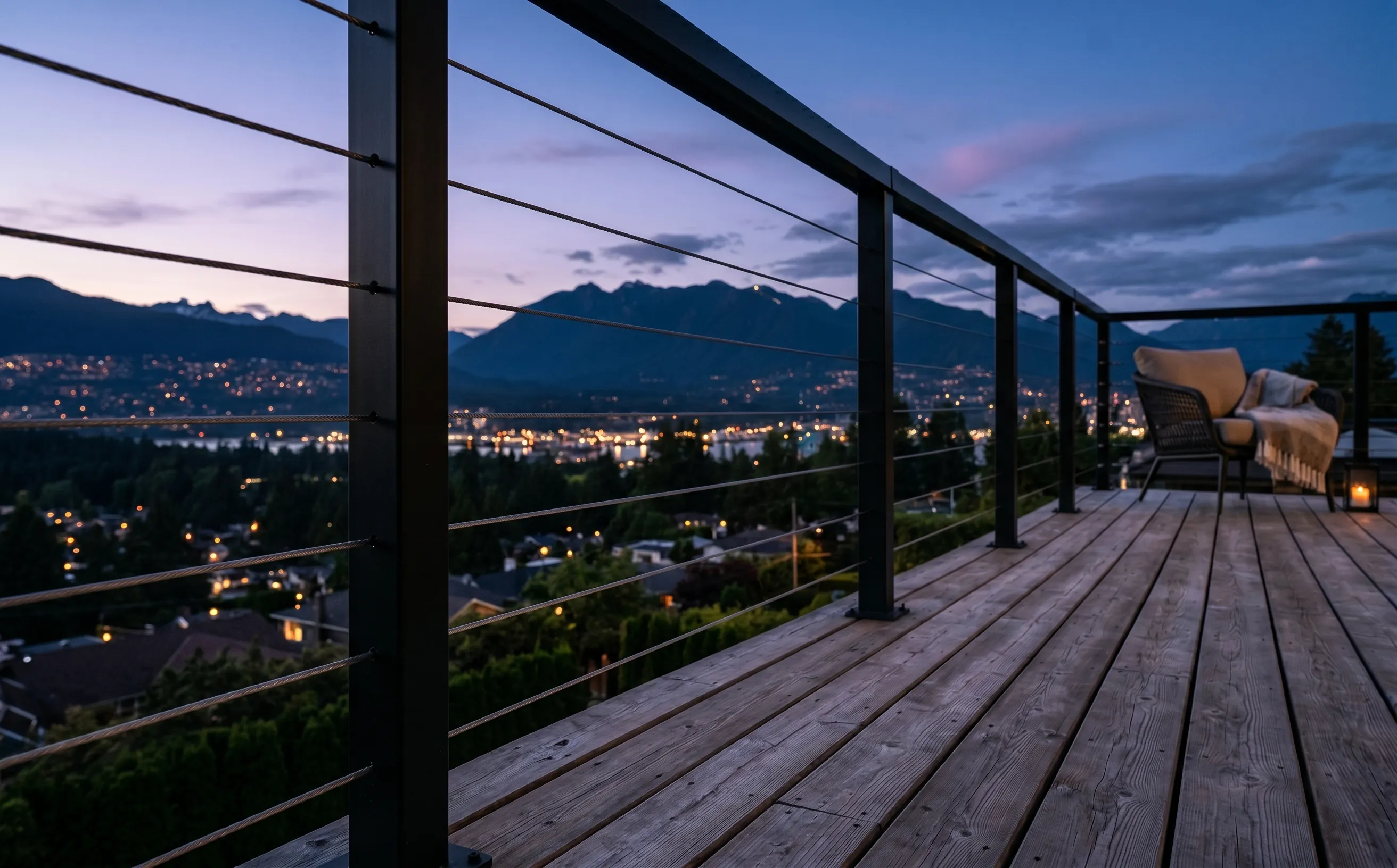 Horizontal black cable deck railing on a North Vancouver home facing the Coast Mountains — the system Vancouver legalized in September 2025