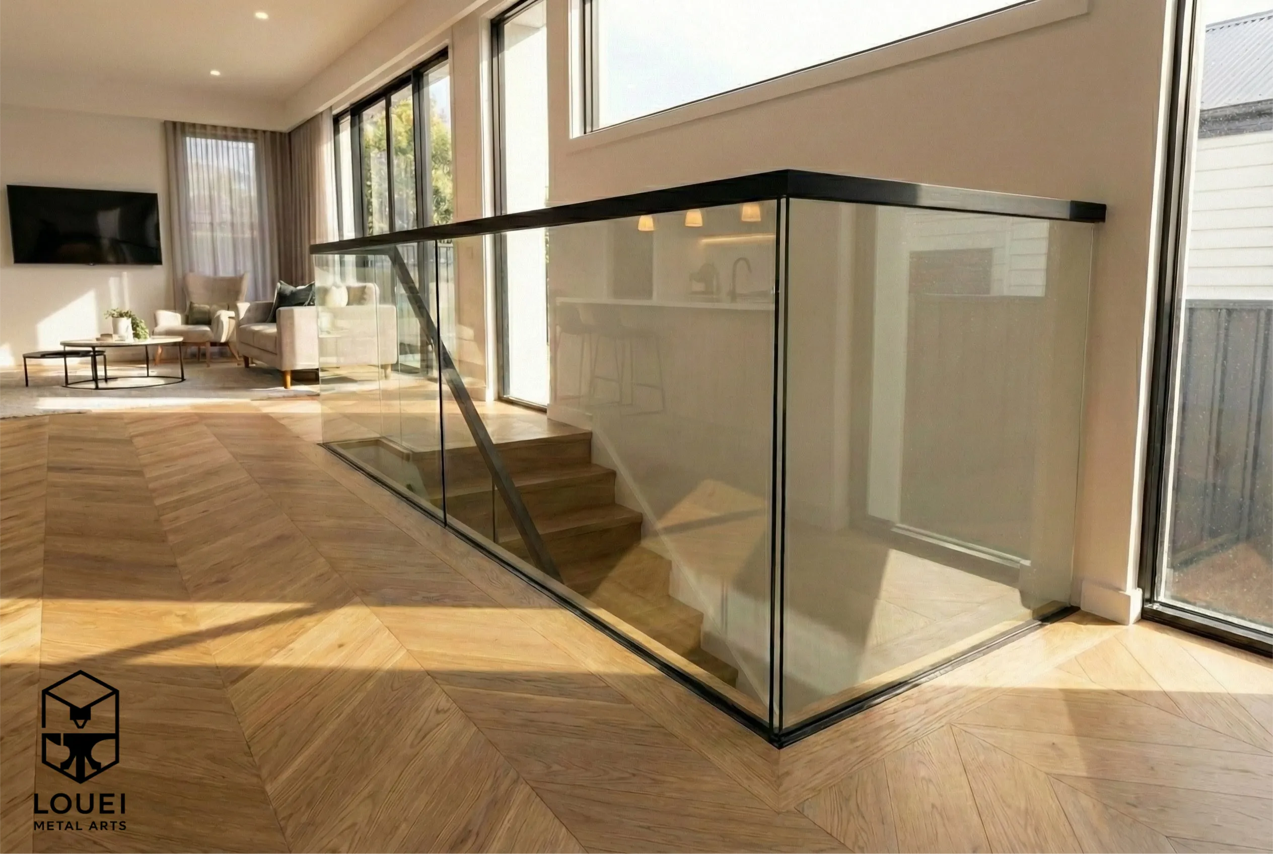 Interior frameless glass railing with a black cap rail enclosing a stair opening on an upper landing.